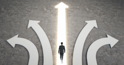Image of several direction arrows with a man walking along a straight glowing arrow