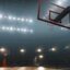 Photo of a dark basketball court with floodlights surrounding.